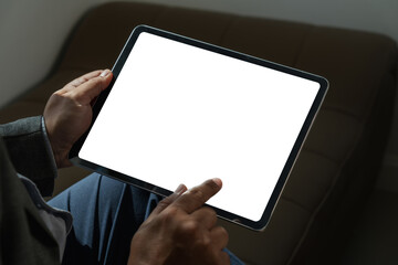A businessman holds a mockup. iPad digital tablet with blank screen Mockup replaces your design mockup in the office. - obrazy, fototapety, plakaty