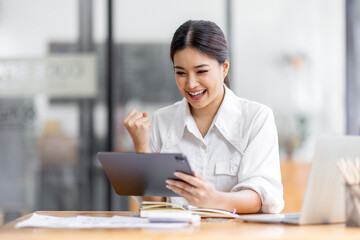 Young happy business asian woman working with tablet in corporate office
