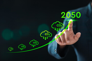 Businessman touch the up arrow with 2050 text and CO2 reducing icons for climate change to limit...