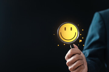 Customer Satisfaction Survey concept, businessman holding magnifying glass focus to smiley face...