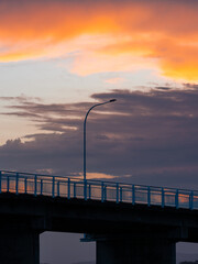A light pole on the bridge at sunset time.