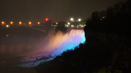 Naklejka na ściany i meble The beautiful Niagara waterfall landscape with the colorful lights on at night