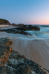 Wave flowing between rock formation at Burgess Beach, NSW, Australia.