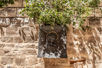 Religious icon hanging on a stone wall in the courtyard on the territory of Church of the...
