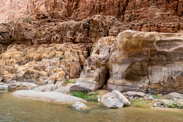 Diversity  of colors of mountain rocks at the beginning of the tourist route in the Mujib River Canyon in Wadi Al Mujib in Jordan