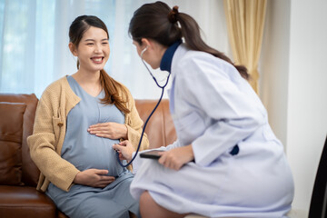 Asian woman who is pregnant Currently receiving a health check from a doctor at home.