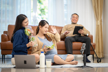 Asian woman who pregnant Eating vegetable salad milk at home via social media Let other mother watch