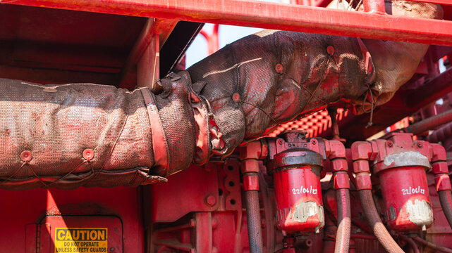 Heat protection material which is wrapped on the hot surface pipeline of pumping machine. Safety equipment and industrial machine part, close-up.