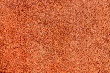 Close-up at orange pastel roughly concrete wall with cracked line on surface. Background and texture photo.