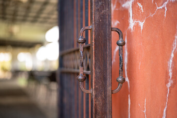 An ancient metal cage door on orange pastel wall, Building part and object photo. Close-up and...