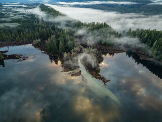 Valley by Lake, Mountains and Green Trees covered in fog. Canadian Nature Aerial Background