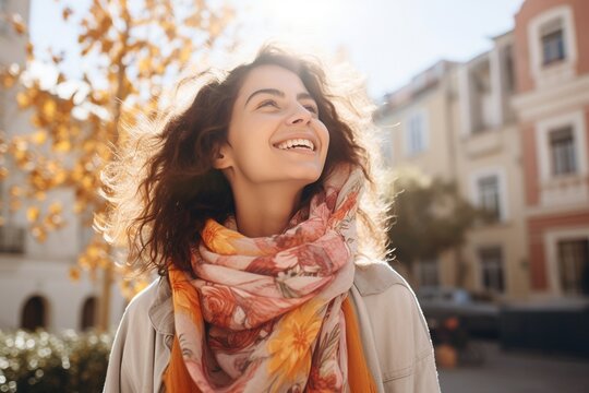 Mujer Sonriente Con Bufanda Colorida Disfruta Del Cálido Sol Otoñal En Ambiente Urbano