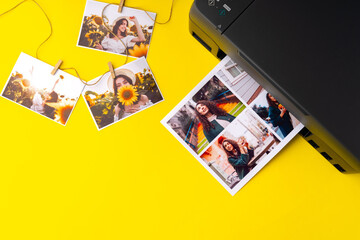 Printer printing colorful photos of people close up, yellow background