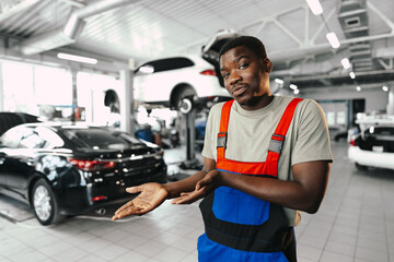 African man mechanic in uniform at the car repair station, portrait