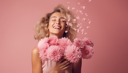 Happy woman in a bright pink dress is smelling a bunch of pink and red flowers