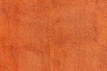 Close-up at orange pastel roughly concrete wall with cracked line on surface. Background and...