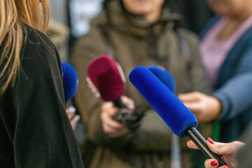Journalists descends upon an event interview,with collective focus on interviewed person.