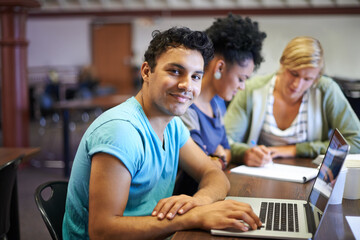Portrait of man, laptop or students in library studying for education in university, college or school. Smile, elearning or people with scholarship on campus reading news, research or online course