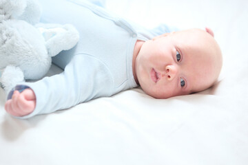 Baby in a white bed, looking with big eyes