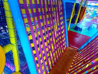 Entrance to the labyrinth with colorful tunnel and bridges, children's room in play Entertainment center. Floor, steps to trampoline. Banner active leisure, free time kids photo. Cozy play area