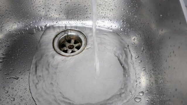 Running tap in Kitchen. Water flowing into steel sink, audio. Studio Shot professional