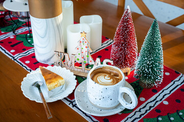 Close up of Hot coffee latte with latte art milk foam in cup mug with Xmas decors and Xmas tree...