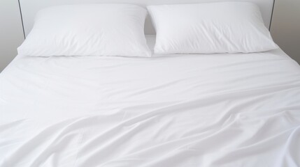 Fototapeta na wymiar Close-up on minimalistic hotel bedding: clean white pillows, duvets, bedsheets neatly placed on a bed