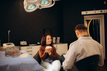 Young woman in clinic chooses breast implant
