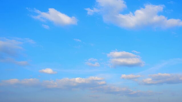 4K : Blue sky time lapse - A celestial ballet in fast-forward. The sky's cerulean palette hosts a mesmerizing performance as fluffy clouds waltz in a timelapse masterpiece. Cloud background.

