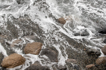 foamy coastal sea wave of a pebble beach