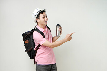 Asian man backpacker hold tumbler bottle and pointing finger gesture. travelling concept. on isolated background