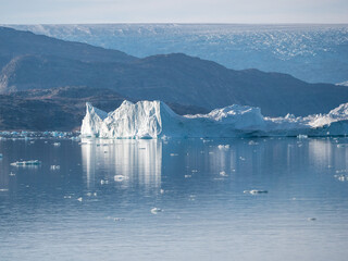 Eisberg in einem grönländischen Fjord mit Gletscher im Hintergrund