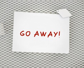 Stick note with text written GO AWAY! -  to tell other to leave me alone, stop disturbing,...