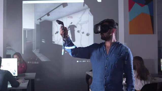 Architect Engineer Using Virtual Reality Software for His Project. Man with Headset and Controllers wearing VR headset for working design 3D architectural building model with BIM technology and