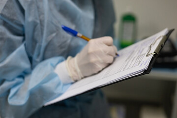 Holding a tablet in his hands, the veterinary anesthesiologist makes notes in the patient's chart....