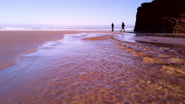 Nice cinematic video clip showing the Cathedrals Beach in Ribadeo, a couple walking along the shore of the beach and photographing this wonderful tourist enclave in Galicia.