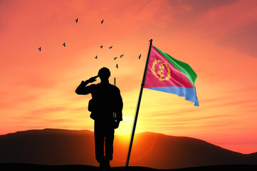 Silhouette of a soldier with the Eritrea flag stands against the background of a sunset or sunrise. Concept of national holidays. Commemoration Day.