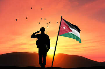 Silhouette of a soldier with the Jordan flag stands against the background of a sunset or sunrise. Concept of national holidays. Commemoration Day. - obrazy, fototapety, plakaty