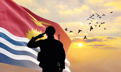 Silhouette of a soldier with the Kiribati flag stands against the background of a sunset or...