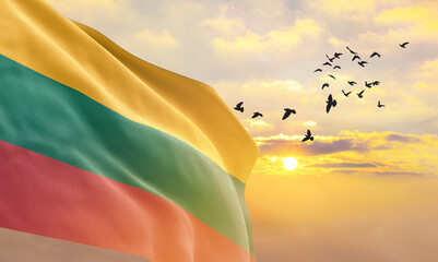 Waving flag of Lithuania against the background of a sunset or sunrise. Lithuania flag for Independence Day. The symbol of the state on wavy fabric. - obrazy, fototapety, plakaty