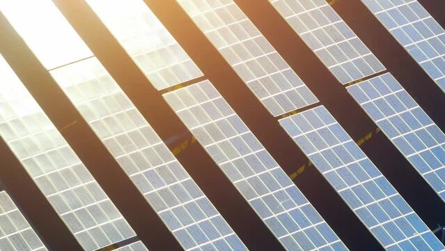 A solar farm comes alive during sunlight, with rows of glistening panels soaking up the sun's rays, creating a dazzling field of clean energy. Carbon footprint and Eco-friendly technology concept.
