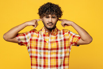 Young sad Indian man he wears shirt casual clothes look camera cover ears with hands fingers do not...