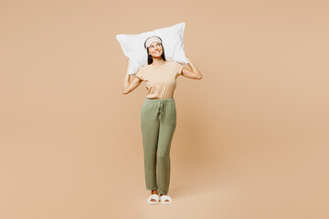 Full body young happy calm Latin woman wears pyjamas jam sleep eye mask rest relax at home hold...