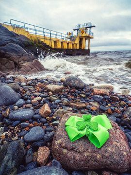Green bow with shamrock on a rock by Blackrock diving tower, Salthill area, Galway city, Ireland. Popular city landmark and tourist viewpoint with stunning nature scenery. Vertical image.