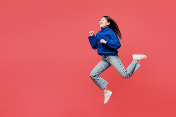 Full body side view happy young woman of Asian ethnicity she wearing blue sweater casual clothes jump high run fast isolated on plain pastel light pink background studio portrait. Lifestyle concept.