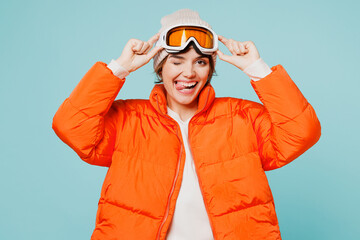 Skier young fun woman wear padded windbreaker jacket hat ski take off goggles mask look camera with...