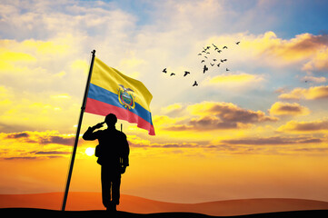 Silhouette of a soldier with the Ecuador flag stands against the background of a sunset or sunrise....