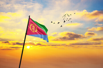 Waving flag of Eritrea against the background of a sunset or sunrise. Eritrea flag for Independence...