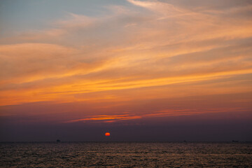 Naklejka premium Beautiful sunset landscape with dramatic sky, sun and sea water