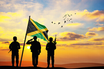 Silhouettes of soldiers with the Jamaica flag stand against the background of a sunset or sunrise. Concept of national holidays. Commemoration Day.